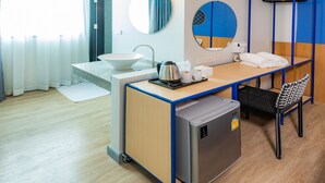 A modern hotel room with a kitchenette, a sink, a mirror, a ceiling fan, and a small refrigerator. - Luck Thai Hotel (Chiang Mai)