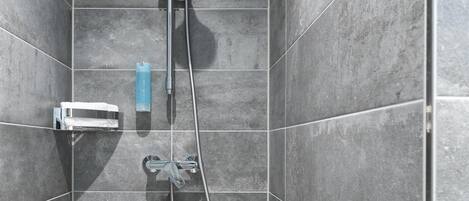 Eine Dusche mit Duschbrause, Handbrause und Wandarmatur.