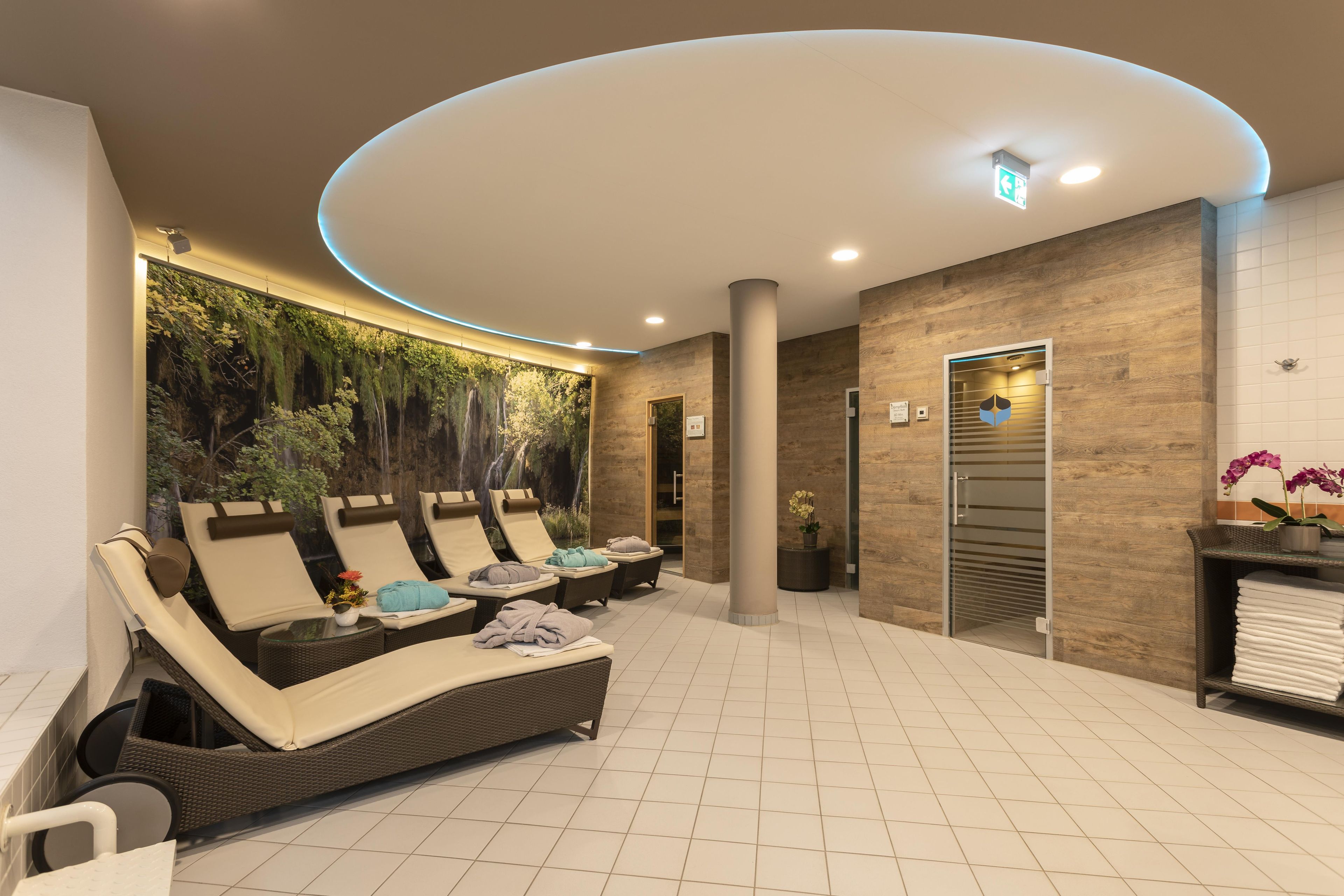 A spa area with reclining chairs, a wall mural, a reception desk, and a reception area.