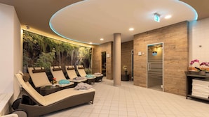 Un área de spa con sillones reclinables, un mural en la pared, un mostrador de recepción y piso de baldosas.