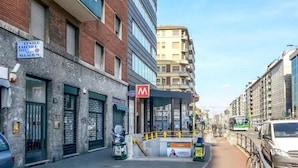 A street view with a mix of modern and older buildings, a visible storefront with a sign, and a parked bicycle. - B&B I Am Here - Gioia 66 (Milan)