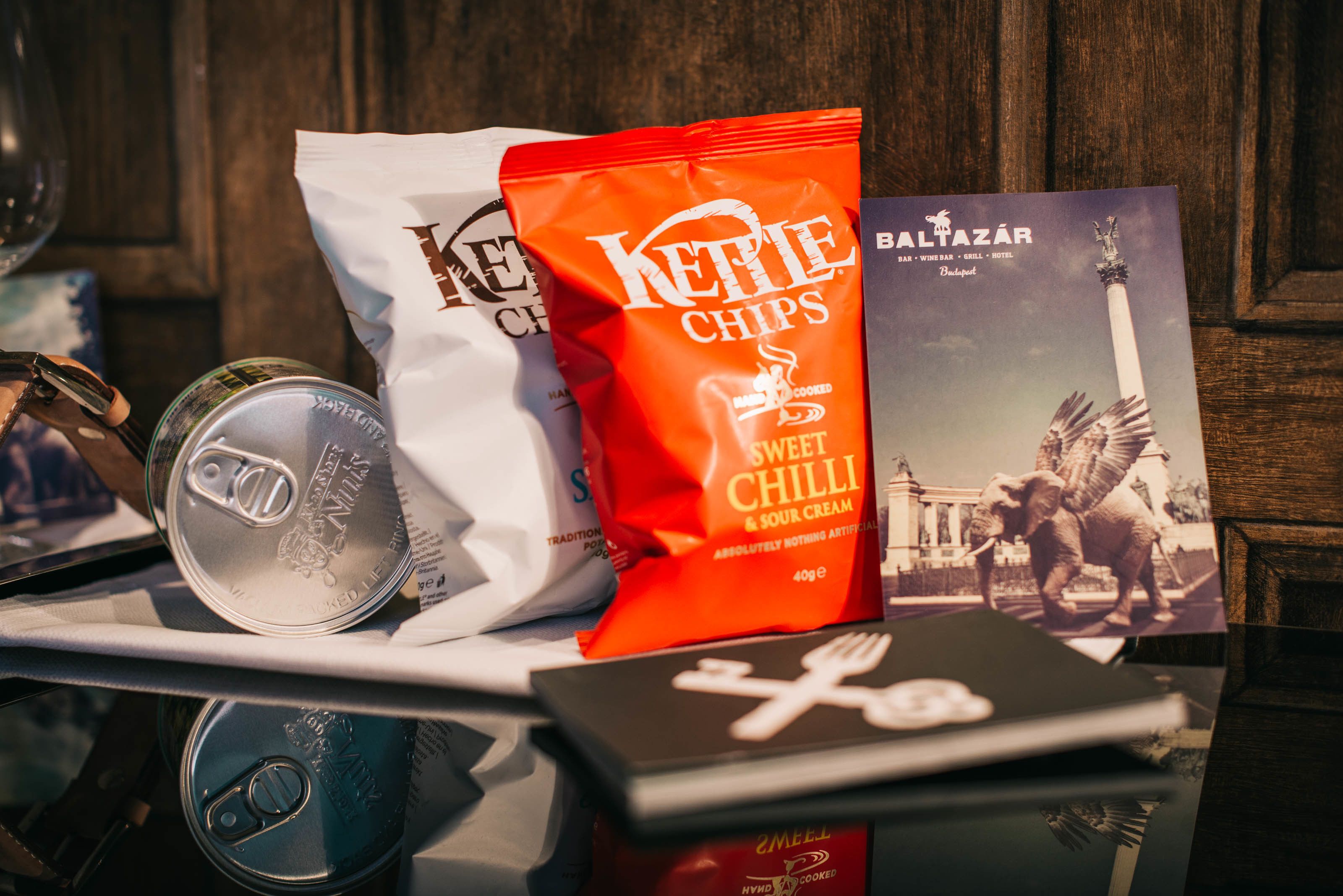 A tray with a can, a bag of Keite chips, a booklet, and a box.