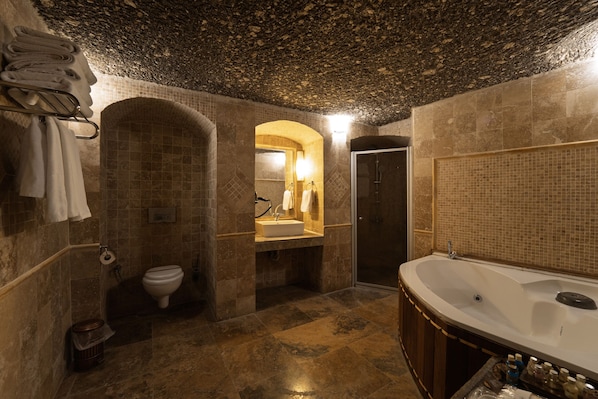 Un baño con una bañera grande, un inodoro y un lavamanos.
