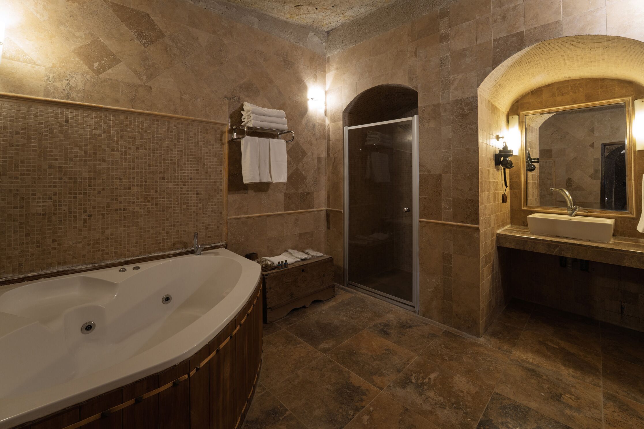 Ein Badezimmer mit einer großen Badewanne, einer separaten Dusche und einem Waschtisch mit Spiegel.