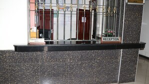 A reception desk with a sign indicating a customer care desk and a reception area.