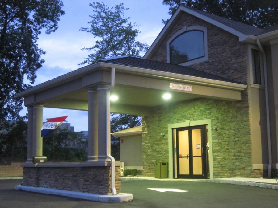 A building with a stone facade, a covered entrance, and a sign indicating a clearance of 10 feet.