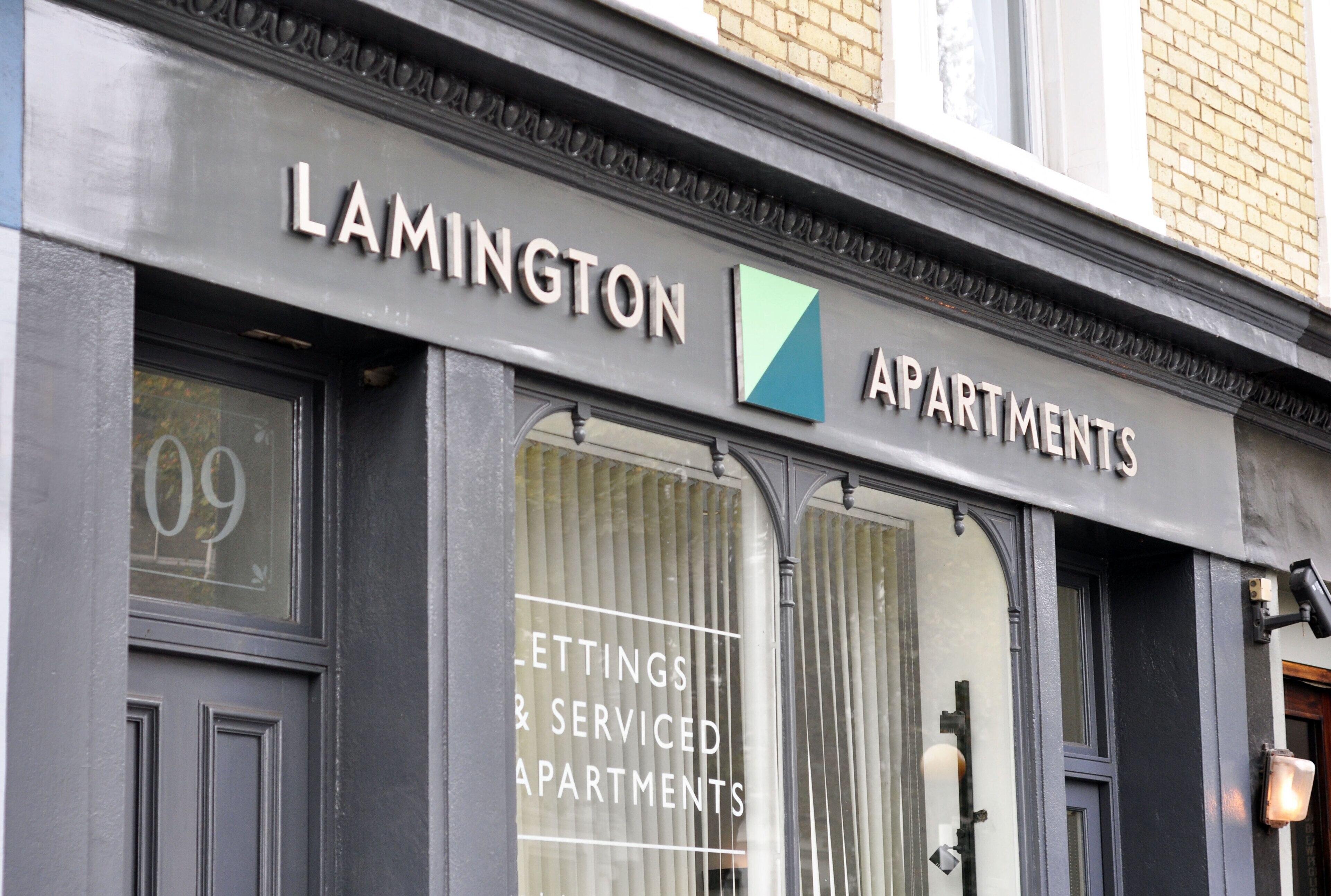 A building with a sign that reads "LAMINGTON APARTMENTS" and "LETTINGS & SERVICED APARTMENTS".