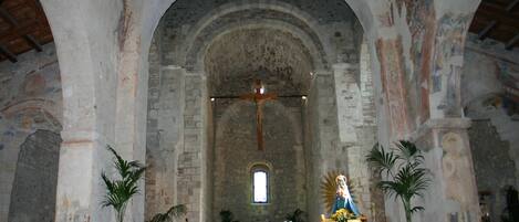 An interior of a church with arched ceilings, a central altar, and religious statues.