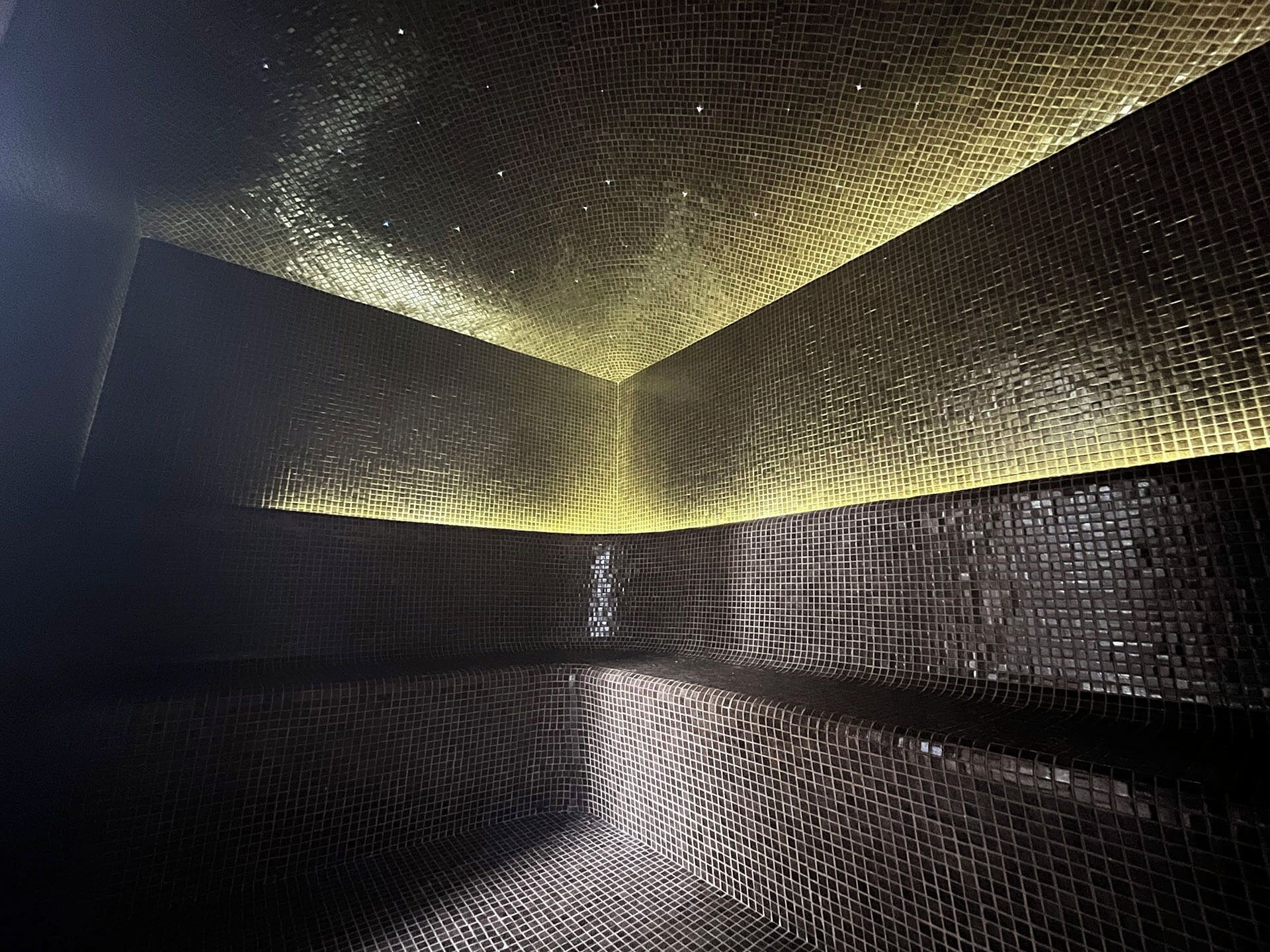A room with a geometric ceiling design and a reflective floor.