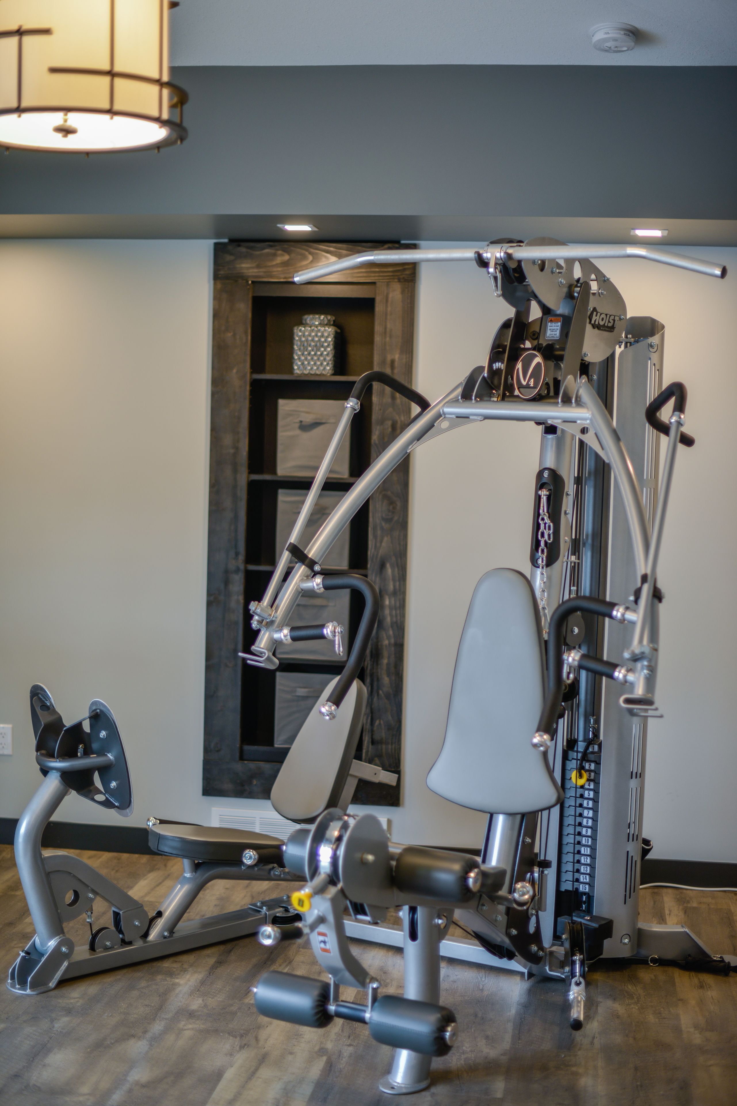 Un gimnasio en casa con una bicicleta estática, elíptica y máquina de pesas.