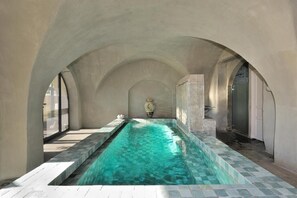 An indoor swimming pool with clear water, surrounded by arched ceilings and stone walls. - Couvent d'Hérépian (Herepian)