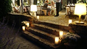 A stone staircase with candles, outdoor tables, and chairs, suggesting a romantic outdoor dining area. - Couvent d'Hérépian (Herepian)