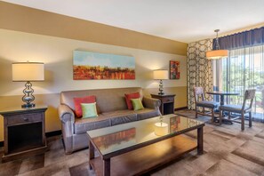 A living room with a sofa, coffee table, lamps, and a painting on the wall. - Carlton Oaks Lodge, an Ascend Collection Hotel (Santee)