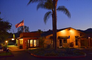 A building with a flag, a golf cart, and a palm tree. - Carlton Oaks Lodge, an Ascend Collection Hotel (Santee)