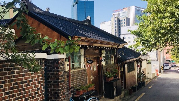 A narrow street with a traditional brick house, a bicycle, and a clear blue sky. - iCOS Guesthouse 1 for Female - Hostel (Seoul)