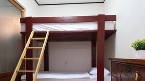 A bunk bed room with a wooden ladder, a dresser with decorative handles, and a ceiling light. - iCOS Guesthouse 1 for Female - Hostel (Seoul)