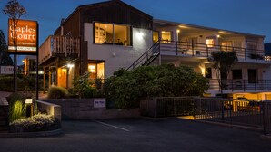 Ein zweistöckiges Hotel mit Balkon, Treppe und einem Schild, das es als Ferienanlage kennzeichnet.