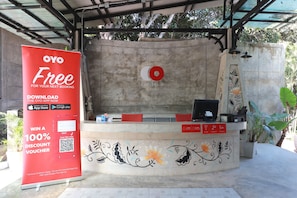 A reception desk with a large red sign advertising a 100% discount voucher for the OYO app. - Capital O 464 At Nata Chiangmai Chic Jungle (Mae Rim)