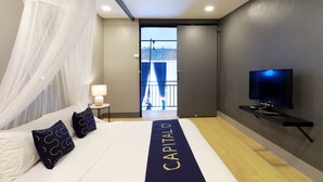 A hotel room with a bed, a TV, a balcony, and a view of the outside. - Capital O 464 At Nata Chiangmai Chic Jungle (Mae Rim)