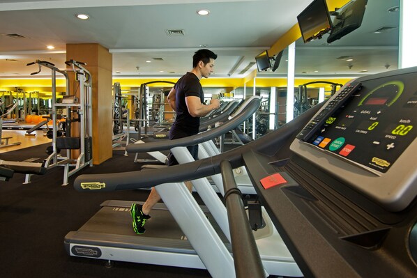 A gym with treadmills, weight machines, and a mirrored wall. - REDTOP Hotel & Convention Center (Jakarta)