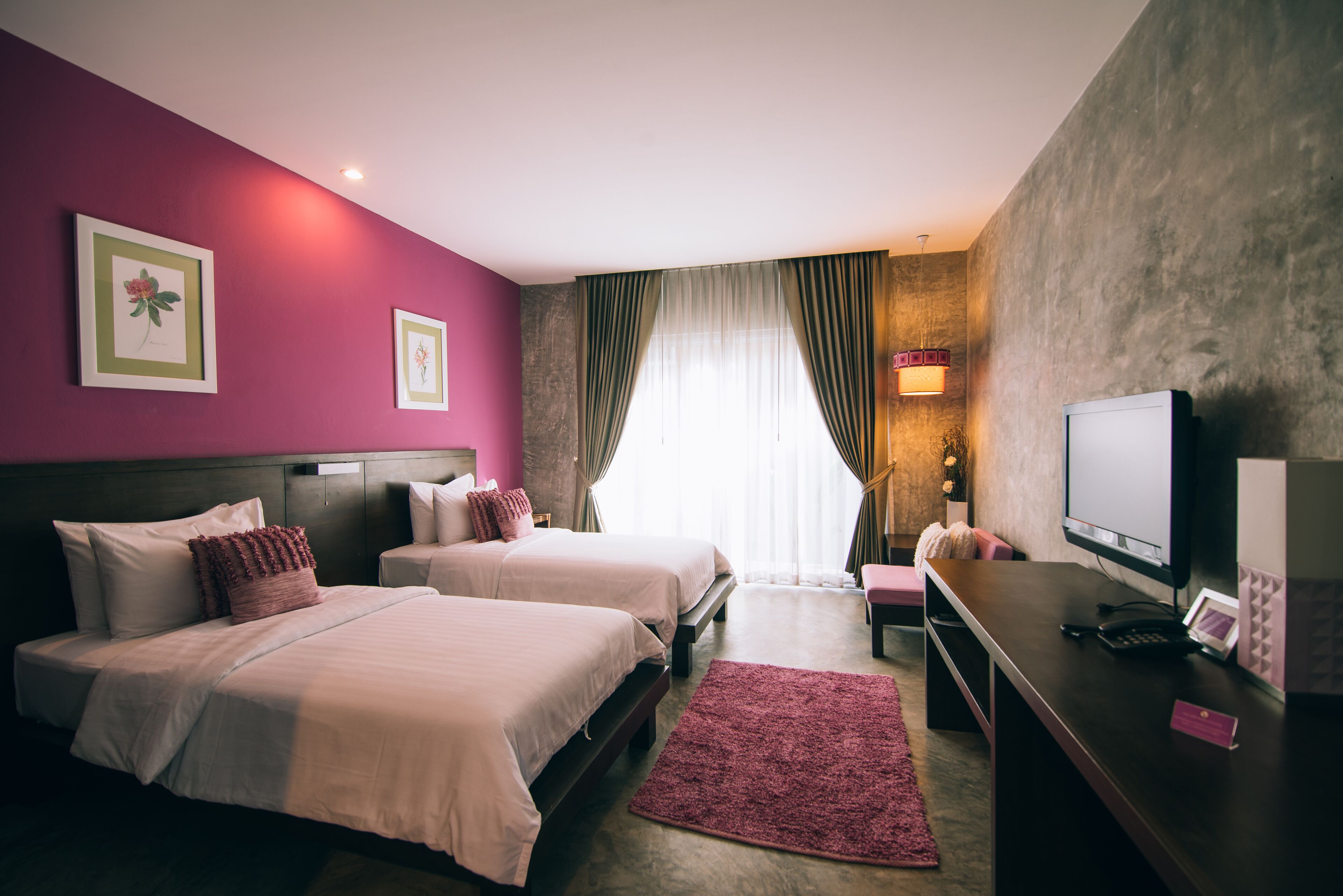 Une chambre d’hôtel avec deux lits, un bureau avec un ordinateur et une télévision.