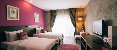 Une chambre d’hôtel avec deux lits, un bureau avec un ordinateur et une télévision.