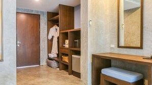 Un baño con tocador de madera, un banco y un espejo.
