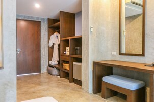 A bathroom with a wooden vanity, a bench, and a mirror.