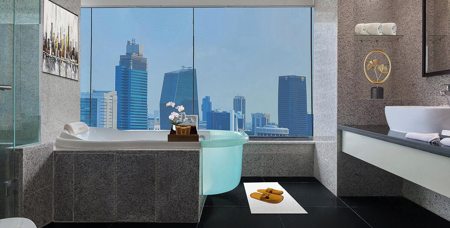 A modern bathroom with a large window, a bathtub, a sink, and a mirror.