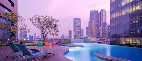 Una piscina al aire libre, sillones reclinables de piscina