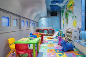 Une salle de jeux pour enfants avec des meubles colorés, un espace de jeu et des jouets éducatifs.
