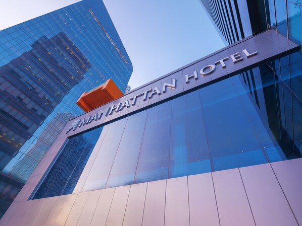 La façade extérieure de l’hôtel Mandarin Oriental, avec son aspect moderne et sa paroi vitrée, ainsi que son panneau indicateur bien visible.