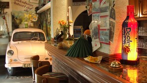 A vintage car, a bottle of Dooley's, and a wall with various photos and signs. - Hotel Gasthof Goldener Hahn (Frankfurt an der Oder)