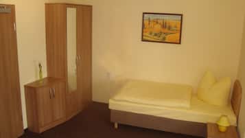 Quarto com cama, guarda-roupa, mesa de cabeceira e um quadro na parede.