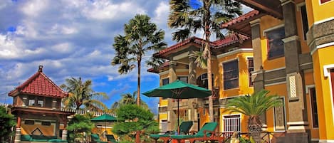 Alberca al aire libre, sombrillas en la alberca y camastros