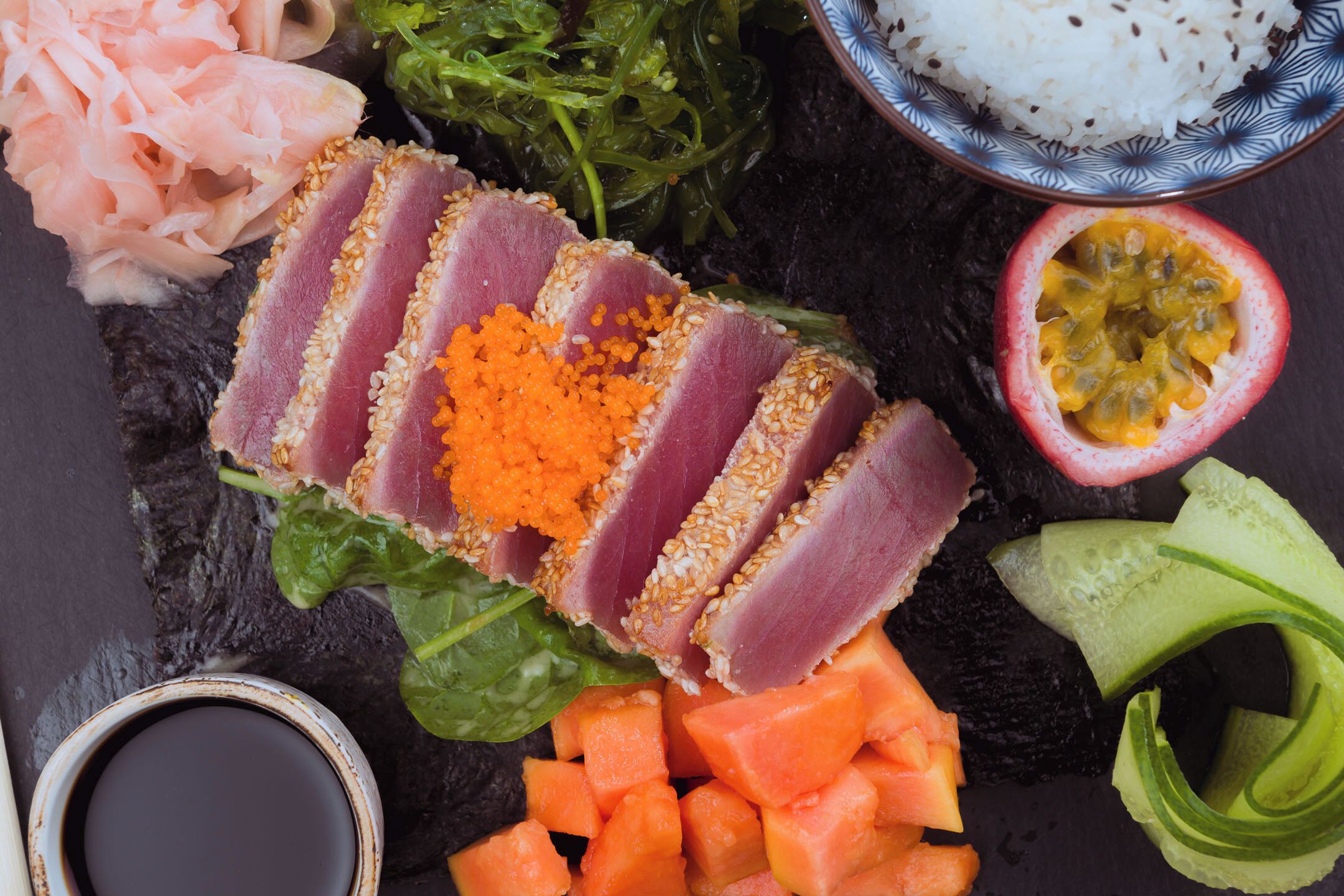 A sushi platter with various toppings and sides.