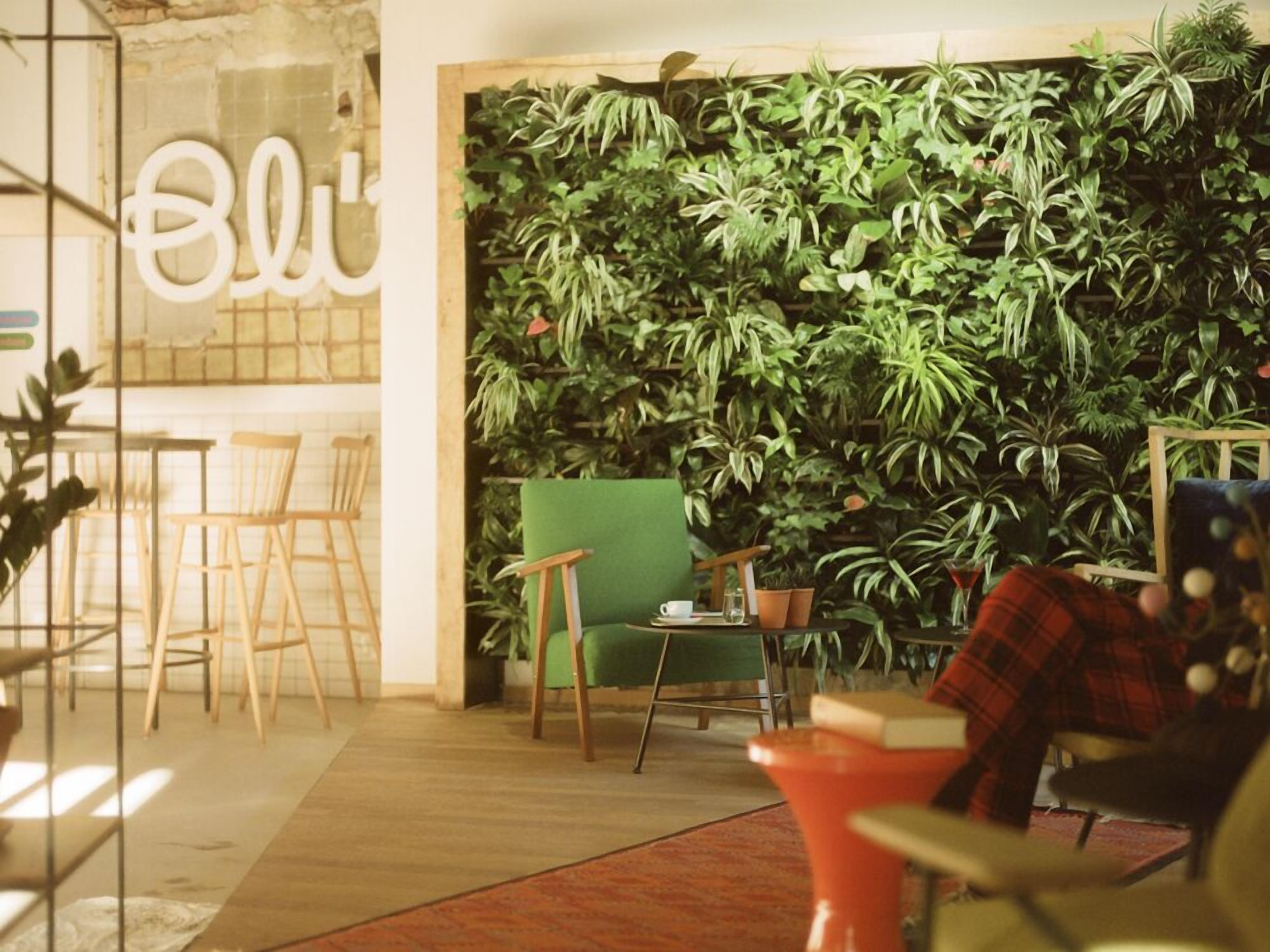 A cozy indoor space with a green chair, a red chair, and a bar area with a wooden counter.