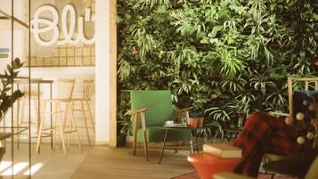 A cozy indoor space with a green chair, a red chair, and a bar area with a wooden counter.
