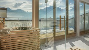 Una habitación moderna con amplias puertas de cristal que dan a un balcón con vistas a la montaña.