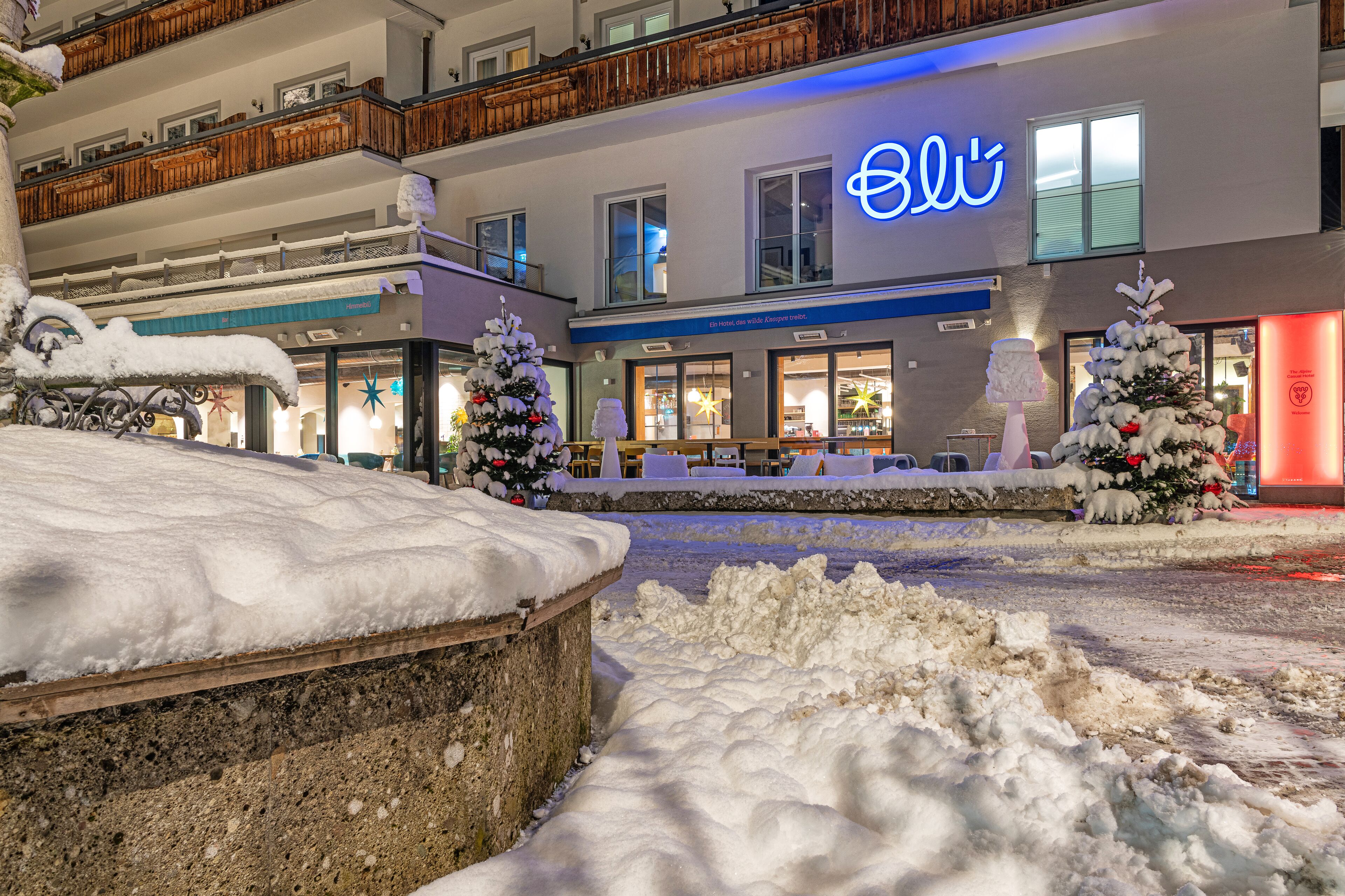 Un hotel amb una entrada coberta de neu i balcons.
