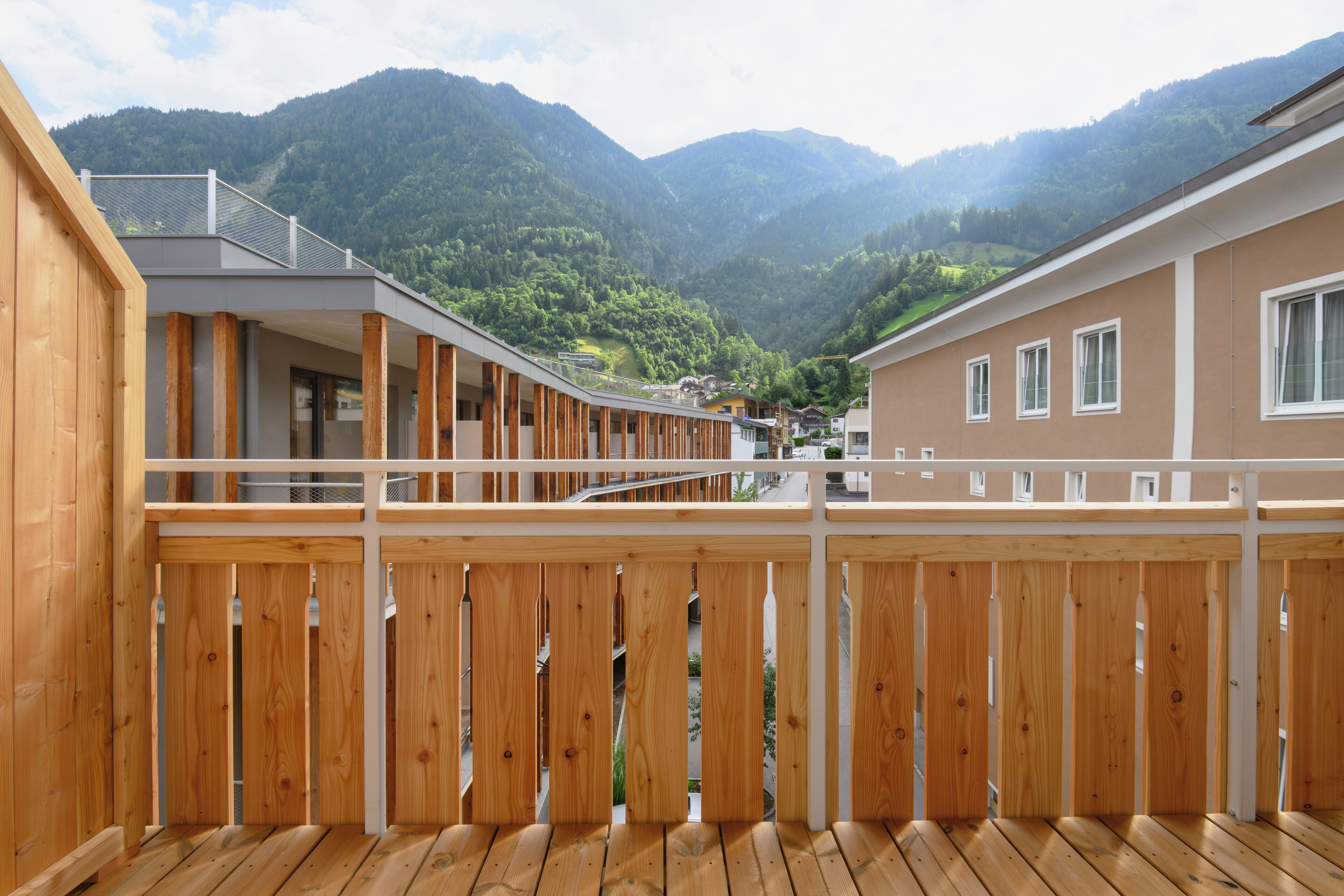 A wooden deck with a view of a mountain range.