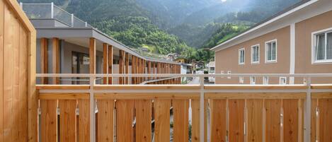A wooden deck with a view of a mountain range.
