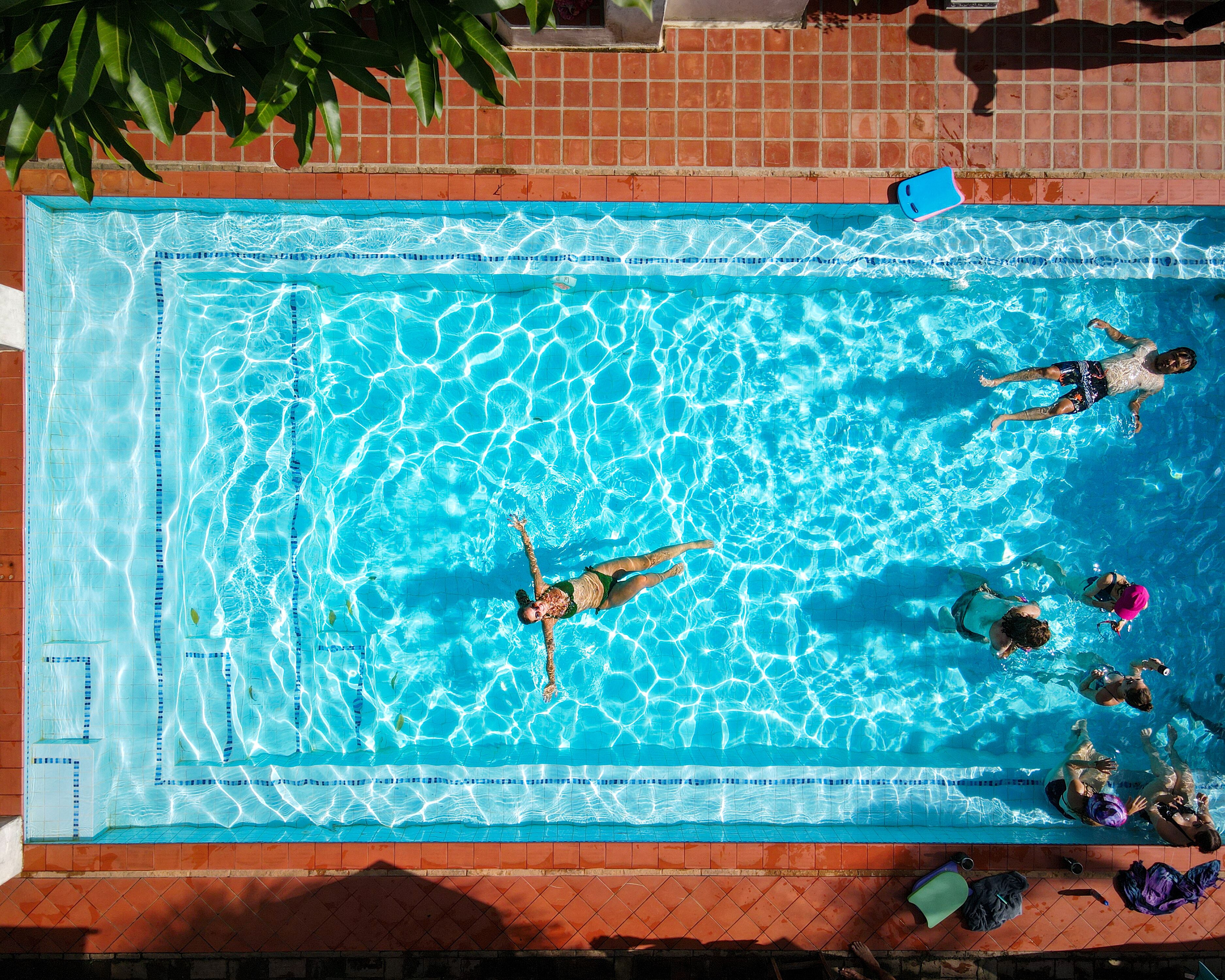 A rectangular swimming pool with clear blue water, surrounded by a tiled deck.