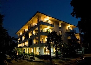 A multi-story hotel with balconies and a well-lit facade.