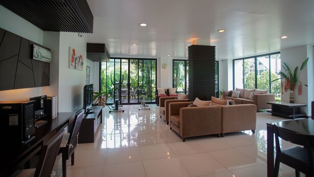 A modern living room with a sofa set, a dining table, and a TV. - Sang Serene House (Chiang Mai)