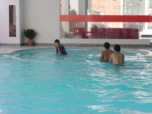 Una piscina techada, sombrillas