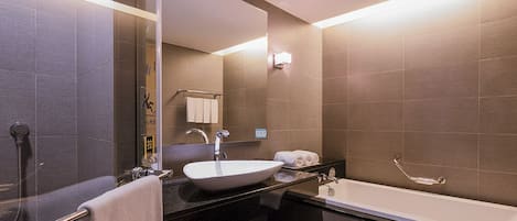 A modern bathroom with a large sink, a bathtub, and a shower.