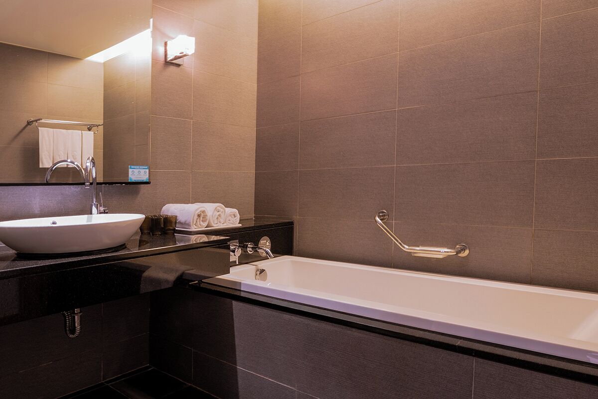 Un baño moderno con una bañera grande, un lavabo y un espejo.