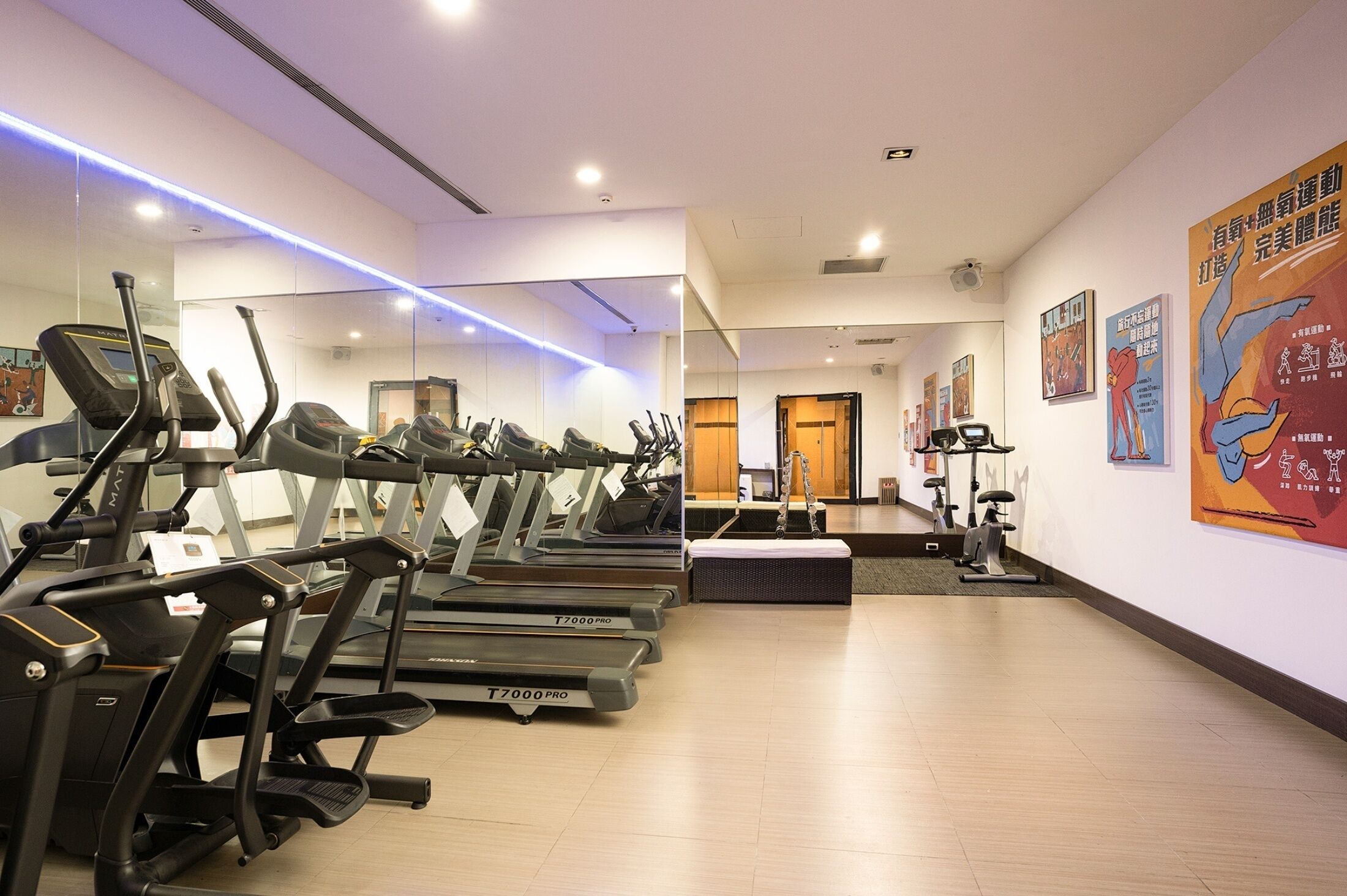 A gym with multiple treadmills, mirrors, and exercise equipment.