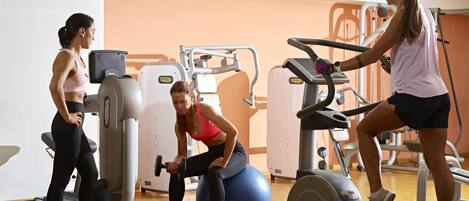 A gym with cardio machines, weightlifting equipment, and exercise balls.